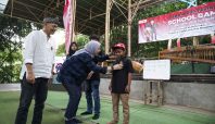 Manager Corporate Social Responsibility AHM Catur Sri Wulandari (Tengah) dan Direktur Utama PT Saung Angklung Udjo Taufik Hidayat Udjo (Kiri) melakukan penyematan pin angklung kepada peserta sebagai tanda dimulainya kegiatan School Camp 2025 (dok Honda).
