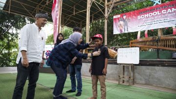 Manager Corporate Social Responsibility AHM Catur Sri Wulandari (Tengah) dan Direktur Utama PT Saung Angklung Udjo Taufik Hidayat Udjo (Kiri) melakukan penyematan pin angklung kepada peserta sebagai tanda dimulainya kegiatan School Camp 2025 (dok Honda).